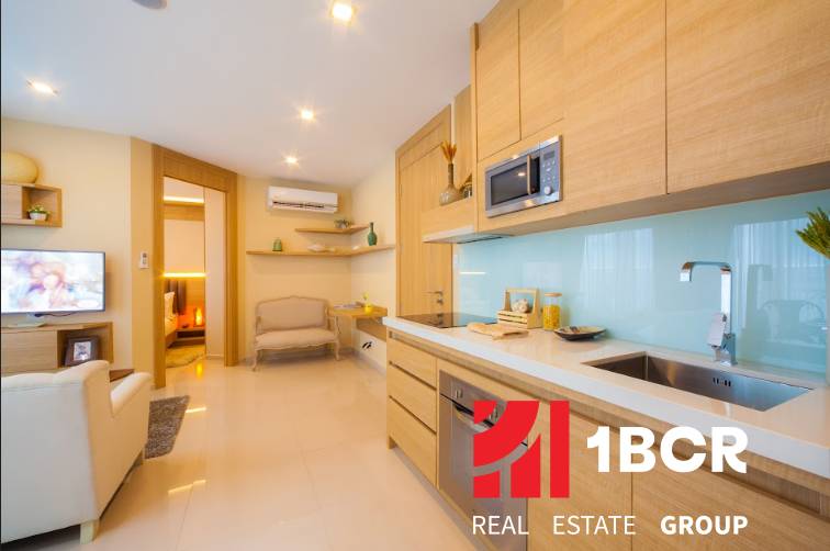2 IZBOVÝ APARTMÁN A (2 SPÁLNE + 1 OBÝV. IZBA) CITY GARDEN OLYMPUS  - Kuchyňa v 3-izbovom byte s drevenými skrinkami, televíziou a výhľadom na obývačku.
