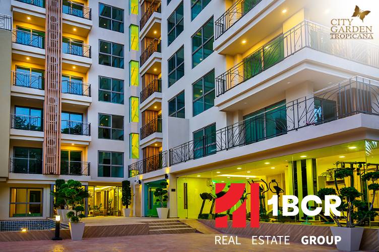 CITY GARDEN TROPICANA PATTAYA - Výstavba bytov v Pattayi: moderná budova s presklenými balkónmi a nočným osvetlením.