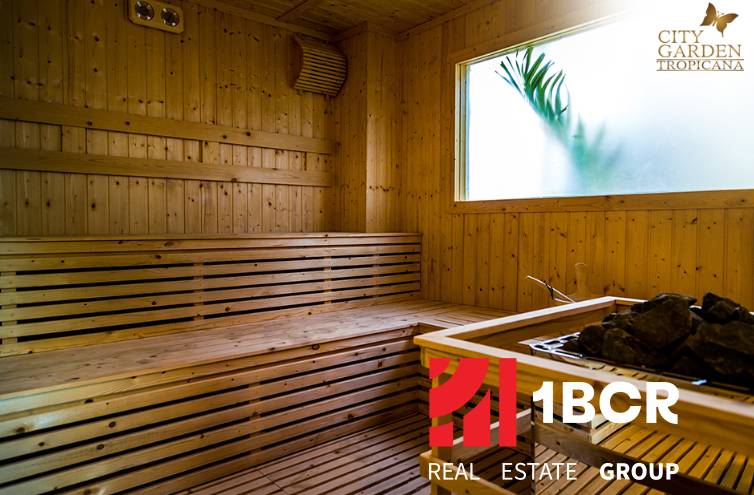 CITY GARDEN TROPICANA PATTAYA - Drevená sauna s preskleným oknom a logom realitnej kancelárie.