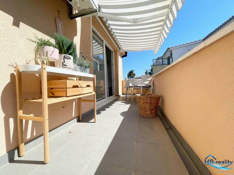 Šolta - nádherný zariadený apartmán s výhľadom na more - Terasa rekreačného apartmánu v Šolte s nábytkom, dekoračnými rastlinami a slnečnou markízou.