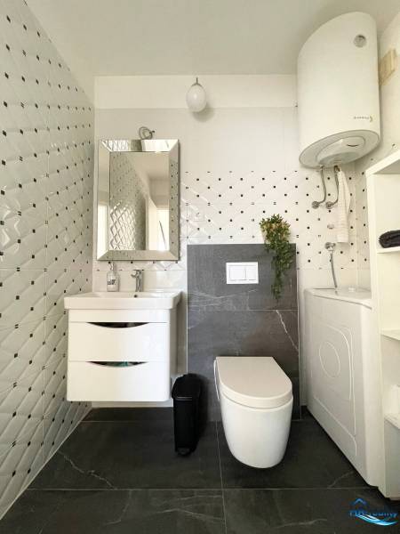 Šolta - nádherný zariadený apartmán s výhľadom na more - Kúpeľňa v rekreačnom apartmáne s úložným priestorom, zrkadlom a práčkou.