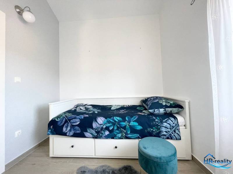 Šolta - nádherný zariadený apartmán s výhľadom na more - Rekreačný apartmán s posteľou a modrou vzorovanou posteľnou bielizňou.
