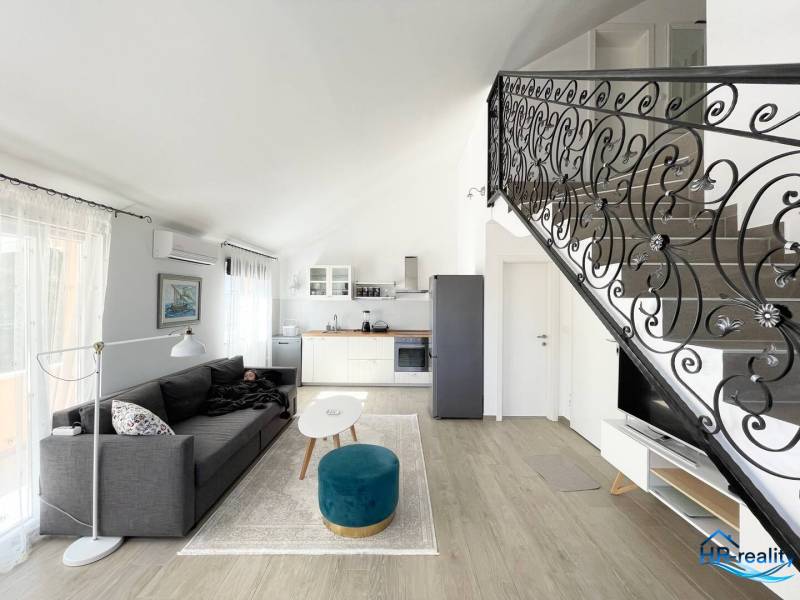 Šolta - nádherný zariadený apartmán s výhľadom na more - Obývacia izba s pohovkou, kuchynským kútom a ozdobným zábradlím, v Rekreačnom apartmáne.