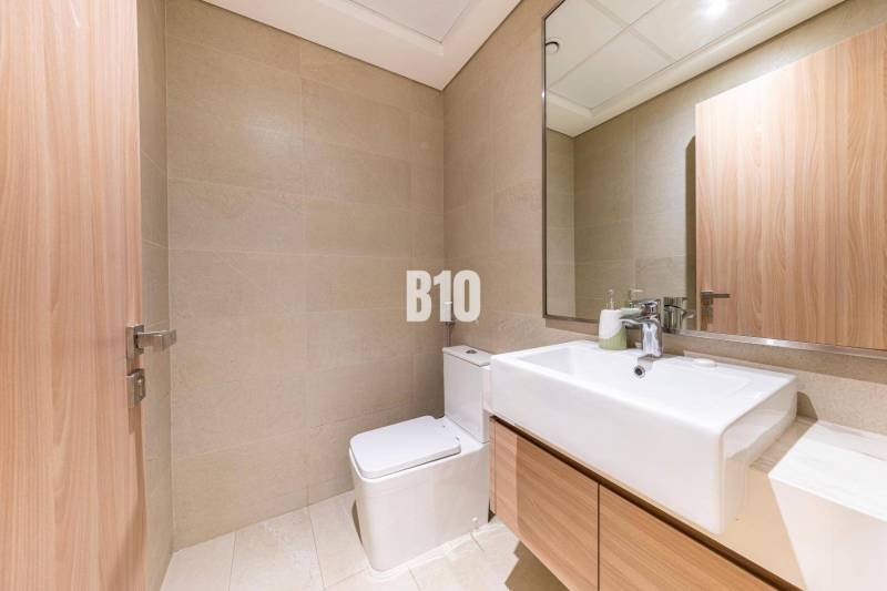 Predaj 3-izbového bytu, Bratislava I - Kúpeľňa v 3-izbovom byte so svetlými obkladmi, zrkadlom a umývadlom.
