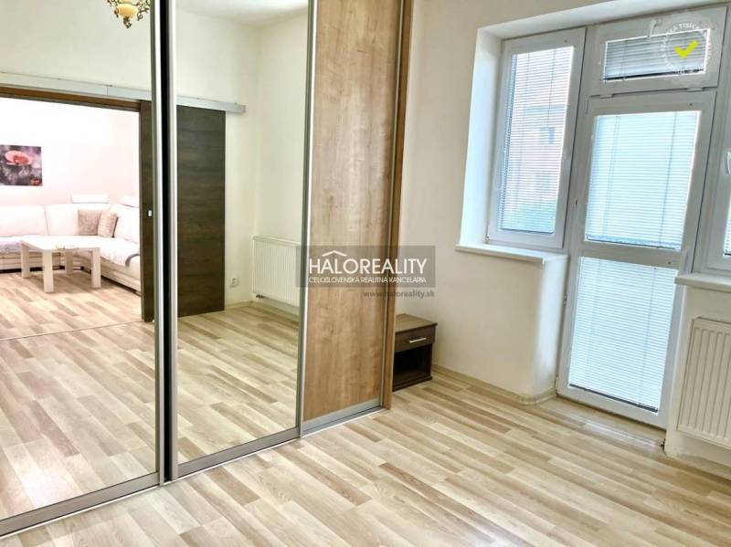 Predaj, trojizbový byt Michalovce - 3-izbový byt s laminátovou podlahou, veľkým zrkadlom a bielymi stenami.