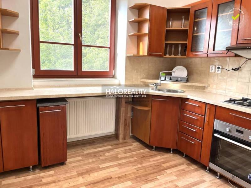 Predaj, trojizbový byt Michalovce - Kuchyňa v 3-izbovom byte s drevenou linkou, okno s výhľadom do zelene.