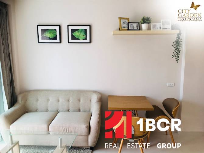 1 IZBOVÝ APARTMÁN (1 SPÁLŇA + 1 OBÝV. IZBA) CITY GARDEN TROPICANA  - Obývacia časť 2-izbového bytu s pohovkou, stolom a dekoráciami na stene.