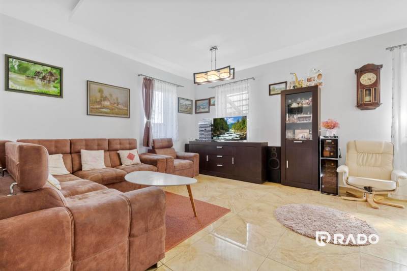 3 nehnuteľnosti na pozemku 4700m2 | Hamuliakovo  - Obývacia izba v rodinnom dome s hnedou sedačkou, kreslami a obrazmi na stenách.