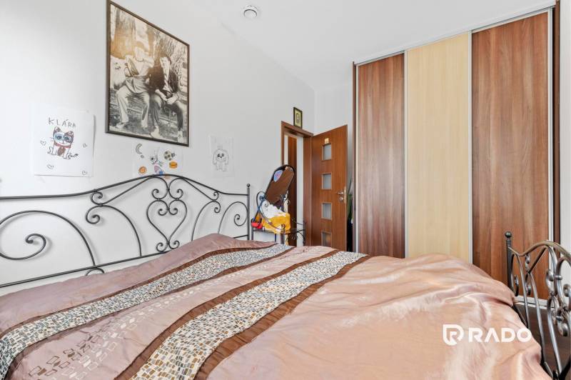 3 nehnuteľnosti na pozemku 4700m2 | Hamuliakovo  - Spálňa v rodinnom dome s kovovou posteľou, obrazmi a vstavanou skriňou.