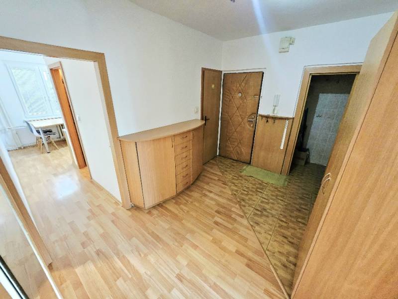 3 izbový byt Bánovce nad Bebravou - 76 m2/ SEVER / KOMPLETNÁ REKONŠTRU - Predsieň 3-izbového bytu s drevenými podlahami a nábytkom, pohľad smerom do izby.