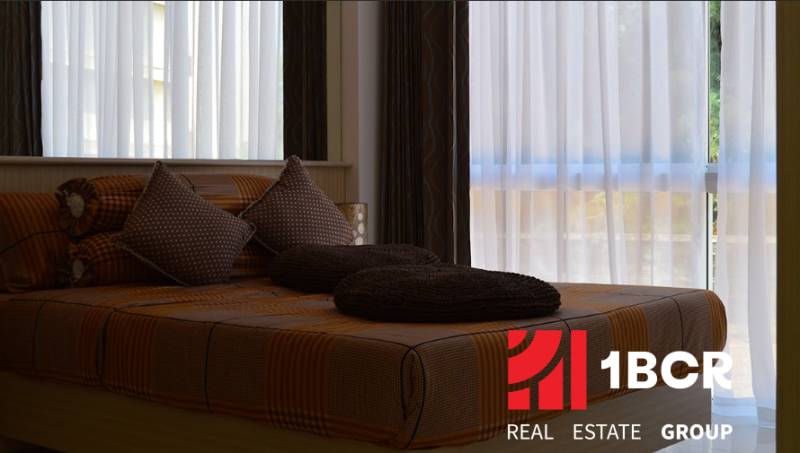 1 IZBOVÝ APARTMÁN (1 SPÁLŇA + 1 OBÝV. IZBA) THE CLOUD PATTAYA - Posteľ s hnedým posteľným prádlom a vankúšmi v 2-izbovom byte.