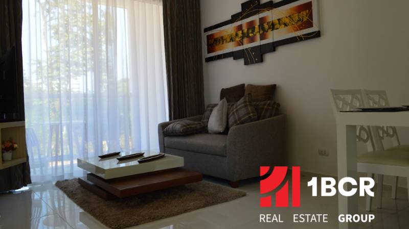 1 IZBOVÝ APARTMÁN (1 SPÁLŇA + 1 OBÝV. IZBA) THE CLOUD PATTAYA - Obývačka v 2-izbovom byte s pohodlnou sedačkou a konferenčným stolíkom.