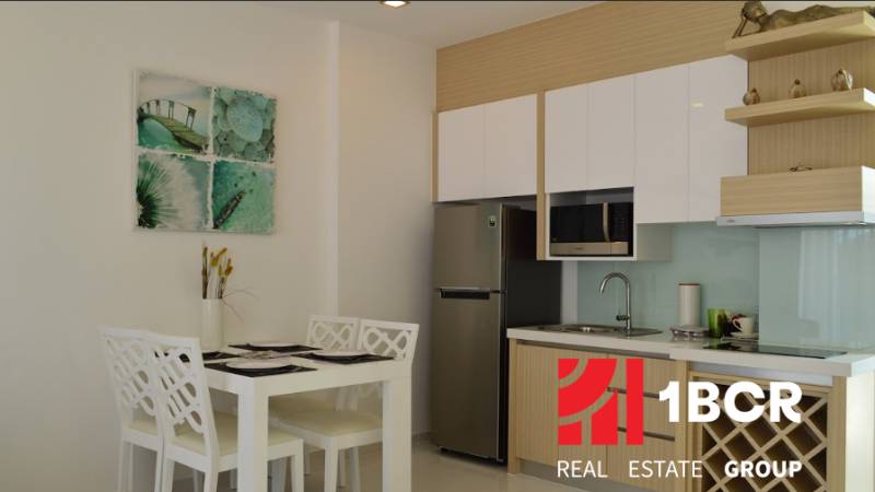 1 IZBOVÝ APARTMÁN (1 SPÁLŇA + 1 OBÝV. IZBA) THE CLOUD PATTAYA - Kuchyňa a jedálenský kút v 2-izbovom byte so štyrmi stoličkami a dekoráciou.