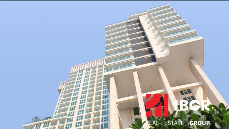 CITY GARDEN TOWER PATTAYA - Výstavba bytov v Pattayi, vysoká budova so sklenenými oknami a balkónmi.