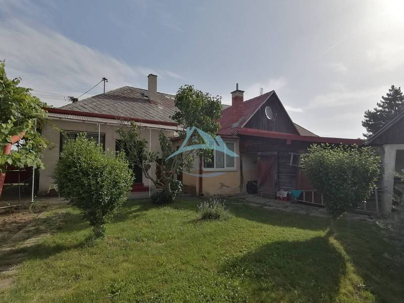 Na predaj rodinný dom v Hrkovciach okres Levice - Rodinný dom v Hrkovciach so záhradou, kríkmi a dreveným prístreškom.