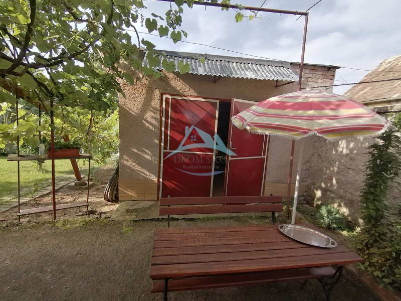 Na predaj rodinný dom v Hrkovciach okres Levice - Záhradka pri rodinnom dome v Hrkovciach so stolom a slnečníkom.