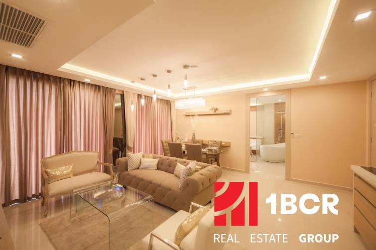 2 IZBOVÝ APARTMÁN (2 SPÁLNE + 1 OBÝV. IZBA) CITY GARDEN TOWER PATTAYA - Luxusný interiér 3-izbového bytu s pohodlnou sedačkou a jedálenským stolom.