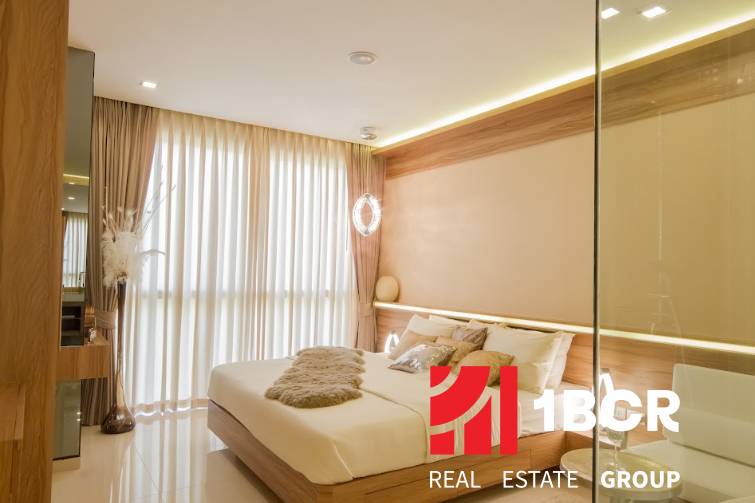 2 IZBOVÝ APARTMÁN (2 SPÁLNE + 1 OBÝV. IZBA) CITY GARDEN TOWER PATTAYA - Štýlová spálňa v 3-izbovom byte s priesvitnými závesmi a drevenými prvkami.