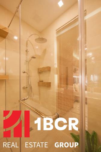 2 IZBOVÝ APARTMÁN (2 SPÁLNE + 1 OBÝV. IZBA) CITY GARDEN TOWER PATTAYA - Sprchovací kút s drevenými poličkami v 3-izbovom byte, zdobený overovacou známkou realitnej kancelárie.
