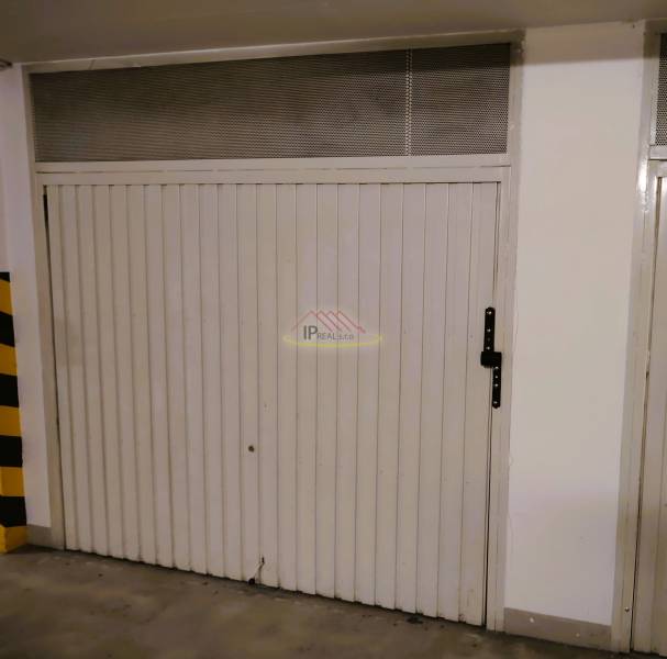 PREDAJ garáž.boxu v podzemnej garáži v BA - Ružinove, ul.Sv. Vincenta. - Biele dvere garáže s kovovou rukoväťou v priestore Garáže.