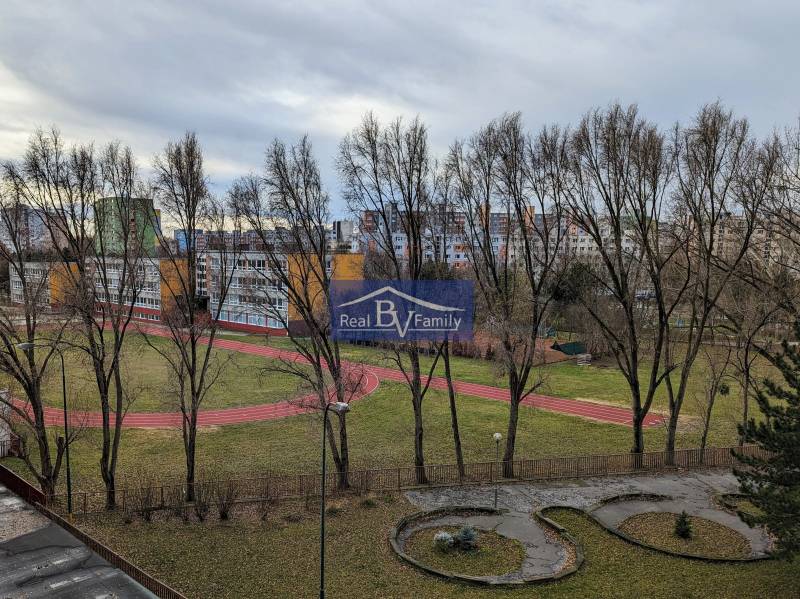 PREDAJ, NÁMESTIE HRANIČIAROV, PETRŽALKA - GARSÓNKA - Výhľad na školský areál s bežeckou dráhou a okolitými bytovkami v Petržalke.