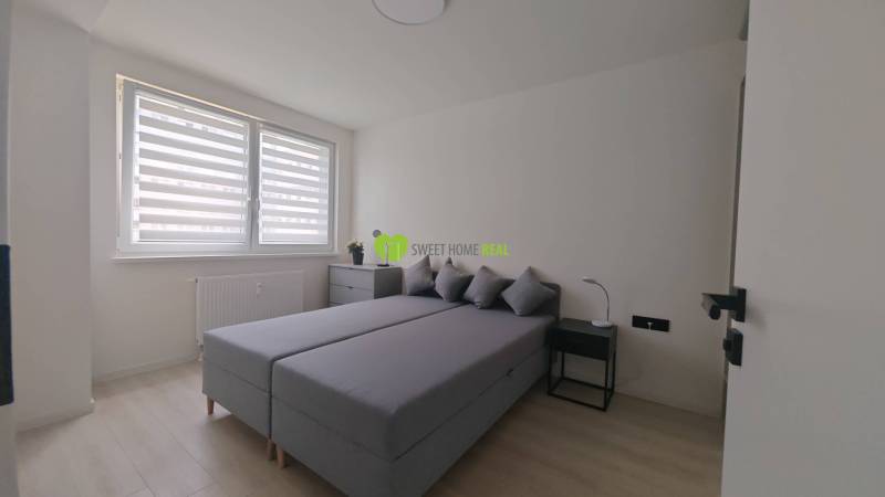 TOP ! na prenájom 1,5i luxusný, klimatizovaný apartmán Košice - Krivá  - Spálňa v 1-izbovom byte s manželskou posteľou, nočnými stolíkmi a oknom s roletami.