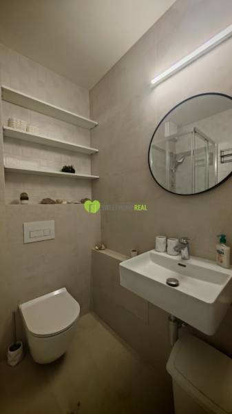 TOP ! na prenájom 1,5i luxusný, klimatizovaný apartmán Košice - Krivá  - Kúpeľňa v 1-izbovom byte s okrúhlym zrkadlom, umývadlom a toaletou.