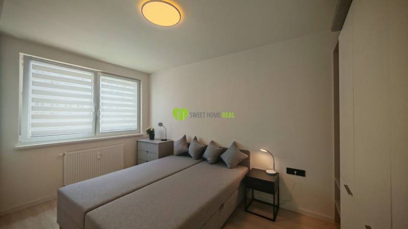 TOP ! na prenájom 1,5i luxusný, klimatizovaný apartmán Košice - Krivá  - Spálňa s posteľou, skrinkou a oknami v 1-izbovom byte, neutrálne farby.