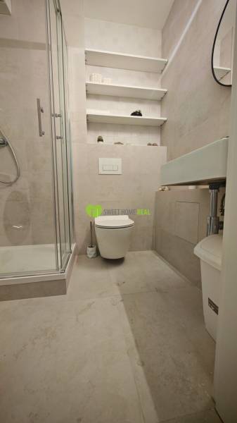TOP ! na prenájom 1,5i luxusný, klimatizovaný apartmán Košice - Krivá  - Kúpeľňa v 1-izbovom byte s toaletou, sprchovým kútom a policami na stene.