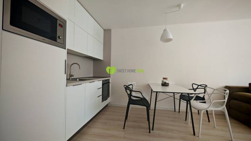 TOP ! na prenájom 1,5i luxusný, klimatizovaný apartmán Košice - Krivá  - Kuchynský kút v 1-izbovom byte s bielymi skrinkami a jedálenským stolom.