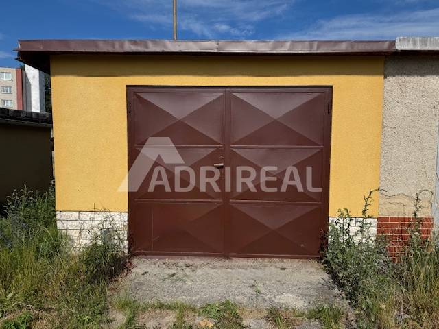 REZERVOVANÉ: Garáž 24 m2; Záhradná; SVIT; 22.000 € - Hnedá garáž na Záhradnej ulici v Svite s rastlinami okolo.