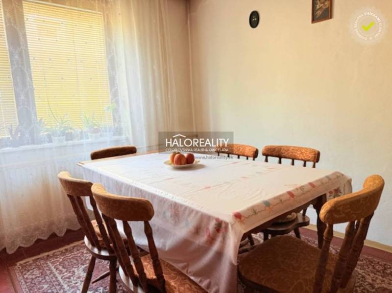 Predaj, rodinný dom Borša - EXKLUZÍVNE HALO REALITY - Jedáleň s dreveným stolom a stoličkami, zdobená záclonami a príborovým obrazom.