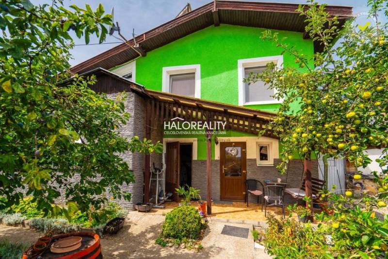 Predaj, rodinný dom Banská Štiavnica - ZNÍŽENÁ CENA ... - Rodinný dom v Banskej Štiavnici s drevenou verandou, obklopený zeleňou a ovocnými stromami.