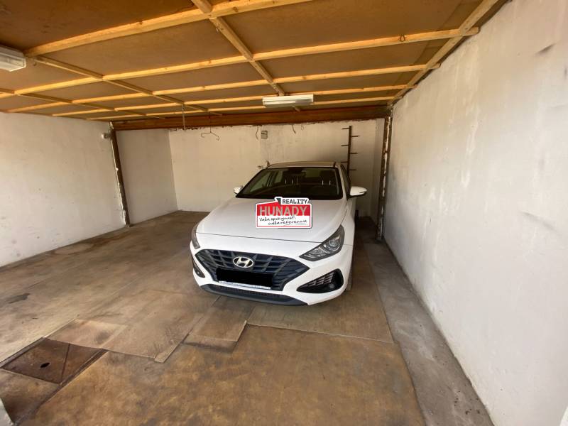 (36 m²) DVOJGARÁŽ ZÁPAD 1  - Interiér garáže s bielym autom značky Hyundai zaparkovaným vo vnútri.