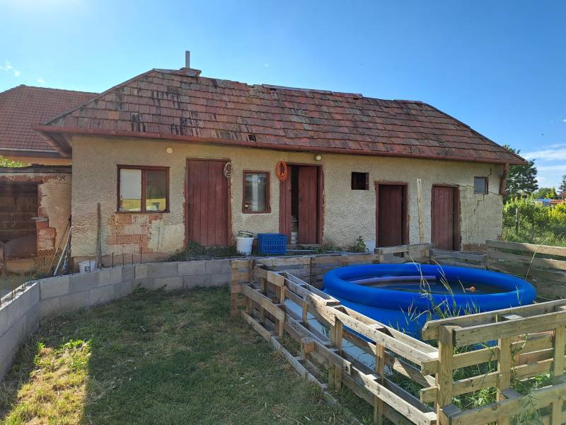 Predáme rodinný dom, pozemok 956 m2, Kmeťovo, okr. Nové Zámky - Rodinný dom v Kmeťove s prístavbou, nafukovací bazén a jednoduchý drevený plot.