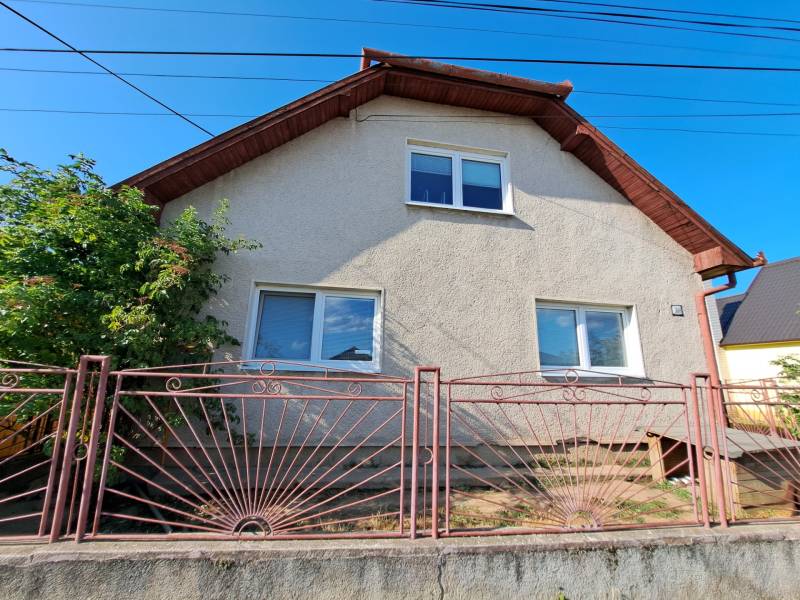 Predáme rodinný dom, pozemok 956 m2, Kmeťovo, okr. Nové Zámky - Rodinný dom v Kmeťove s bielou fasádou a kovovým plotom.