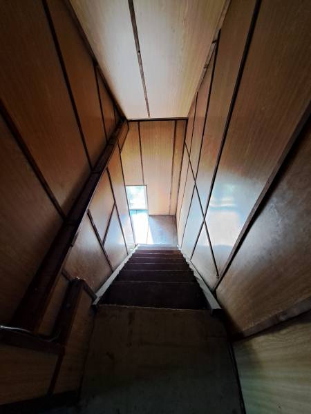 Predáme rodinný dom, pozemok 956 m2, Kmeťovo, okr. Nové Zámky - Schodisko s drevenými stenami vedúce k úzkemu oknu v rodinnom dome.