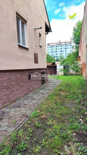 REZERVOVANÉ - Predaj, rodinný dom Lučenec, centrum -... - Úzky chodník pri rodinnom dome v Lučenci s trávou a zeleňou.