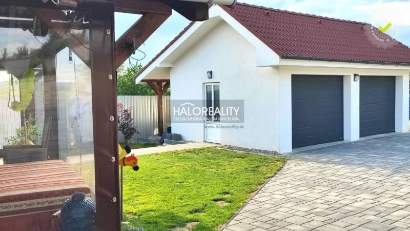 REZERVOVANÉ - Predaj, rodinný dom Kalinovo - EXKLUZÍ... - Exteriér rodinného domu v Kalinove s trávnikom, terasou a dvojgarážou.