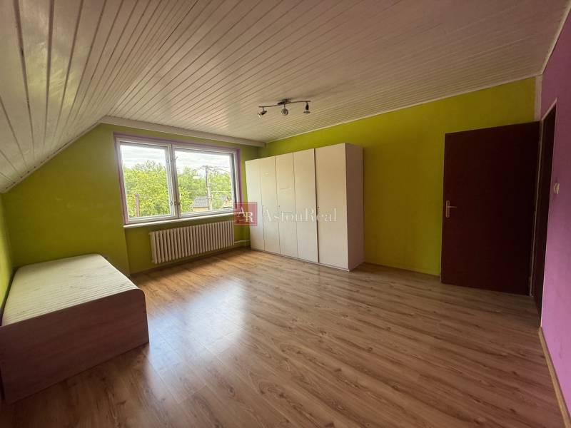 Dvojgeneračný 7i.rodinný dom v Záriečí vhodný na bývanie aj podnikanie - Izba v rodinnom dome s laminátovou podlahou, farebnými stenami, posteľou a šatníkom.