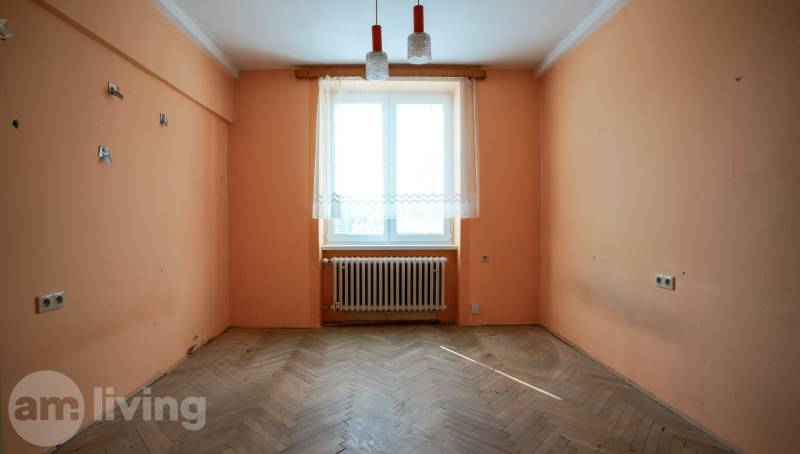 NOVINKA - 2 izbový tehlový byt - Nová Dubnica - 60m²  - Prázdna izba v 2-izbovom byte s oranžovými stenami a drevenou podlahou.