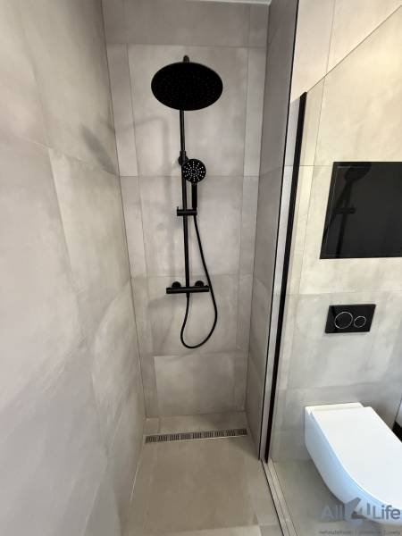 Moderný 2-izbový byt s terasou a parkovaním v Piešťanoch - Sprchovací kút a záchod s čiernymi doplnkami v 2-izbovom byte.