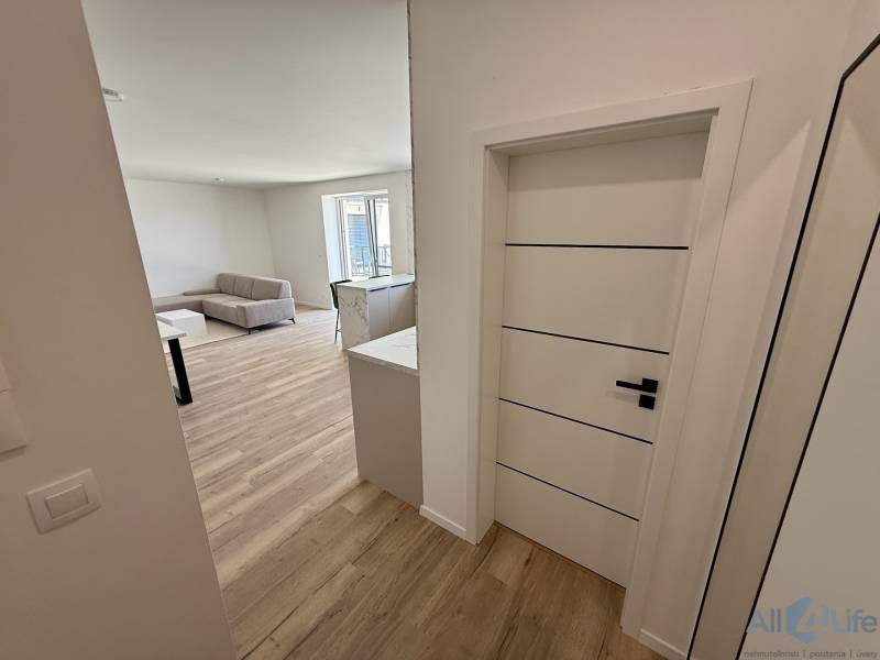Moderný 2-izbový byt s terasou a parkovaním v Piešťanoch - Vstupná hala vedúca do obývacej izby v 2-izbovom byte s drevenou podlahou.