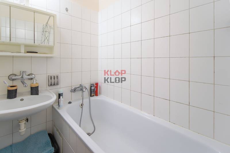 Kúpte si TICHÝ, VEĽKORYSÝ 1i byt s BALKÓNOM a výhľadom na Kamzík - Kúpeľňa s vaňou, umývadlom a bielymi obkladačkami v 1-izbovom byte.