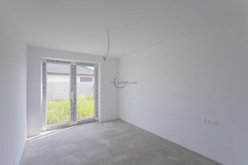 NA PREDAJ NOVOSTAVBA moderný 4-izbový rodinný dom s garážou v Zohore - Prázdna miestnosť s bielymi stenami a presklenými dverami v rodinnom dome.