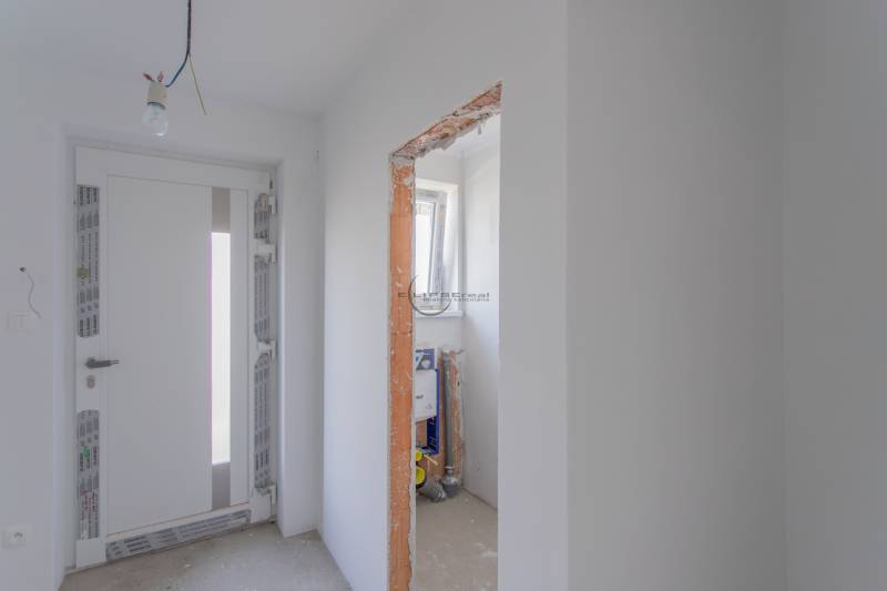 NA PREDAJ NOVOSTAVBA moderný 4-izbový rodinný dom s garážou v Zohore - Interiér rodinného domu s bielymi stenami, osvetlenie a nezakrytý stavebný otvor.