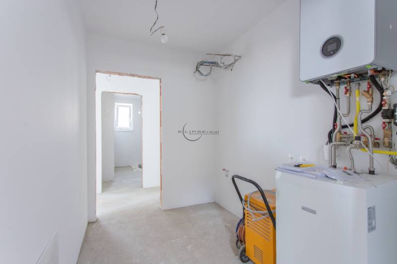 NA PREDAJ NOVOSTAVBA moderný 4-izbový rodinný dom s garážou v Zohore - Technická miestnosť v rodinnom dome so zariadením na vykurovanie a viditeľnými káblami.