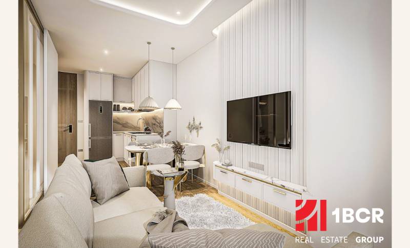 1 IZBOVÝ APARTMÁN (1 SPÁLŇA + 1 OBÝV. IZBA) SEASPIRE JOMTIEN PATTAYA - Obývacia izba s kuchyňou v 2-izbovom byte, svetlé farby a pohodlné sedenie.