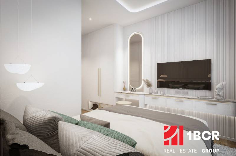 2 IZBOVÝ APARTMÁN (2 SPÁLNE + 1 OBÝV. IZBA) SEASPIRE JOMTIEN PATTAYA - Svetlá spálňa s posteľou a zrkadlom v 3-izbovom byte, televízor na stene.