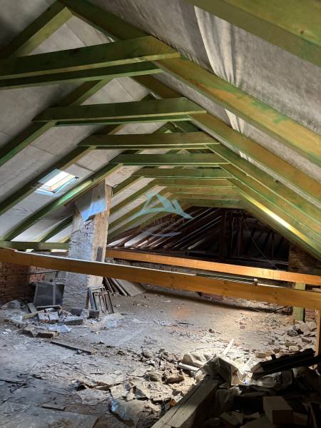 Obchodné priestory na predaj centrum mesta Šahy - Povala obchodných priestorov s drevenou konštrukciou a stavebným materiálom roztrúseným po podlahe.